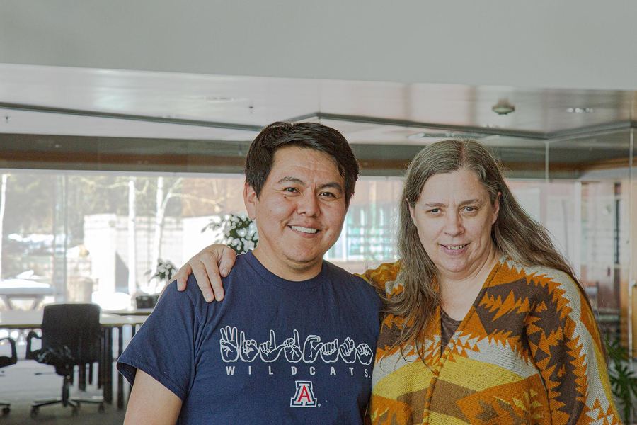 Two people posing together, one wearing a Wildcats shirt with hand signs